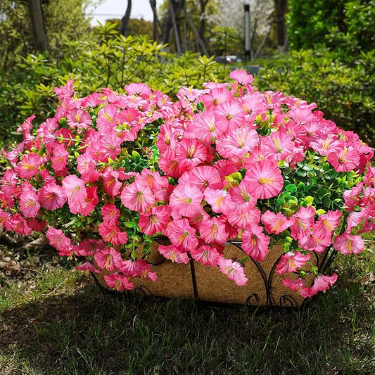 Dense pink faux morning glory flower bundle with green foliage on outdoor planter