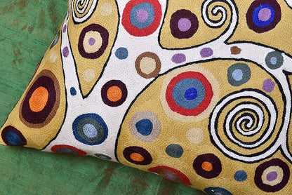 Decorative embroidered pillow cover close-up with yellow, white and colorful swirl motifs