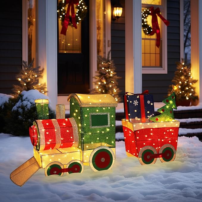 Light-up Christmas train decor set with green engine, red cars, and gift boxes on snow