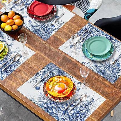 Blue-and-white Christmas tree placemats on a dining table with plates and drinks