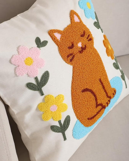 Close-up of cream cat throw pillow cover with embroidered orange cat and pastel flowers