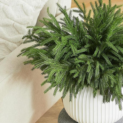 Green faux pine branch stem with dense needles, in a ribbed white planter