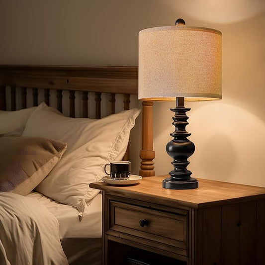 Table lamp set of 2 with beige fabric shades and dark stacked-resin bases on nightstand