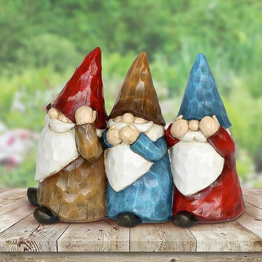 Three painted garden gnome statues, red blue brown hats and white beards, kneeling trio