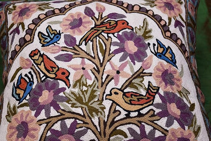 Front close-up of tree-and-birds needlepoint pillow cover with purple flower blooms