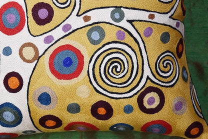 Decorative pillow cover detail: yellow and white with bold circular swirl embroidery
