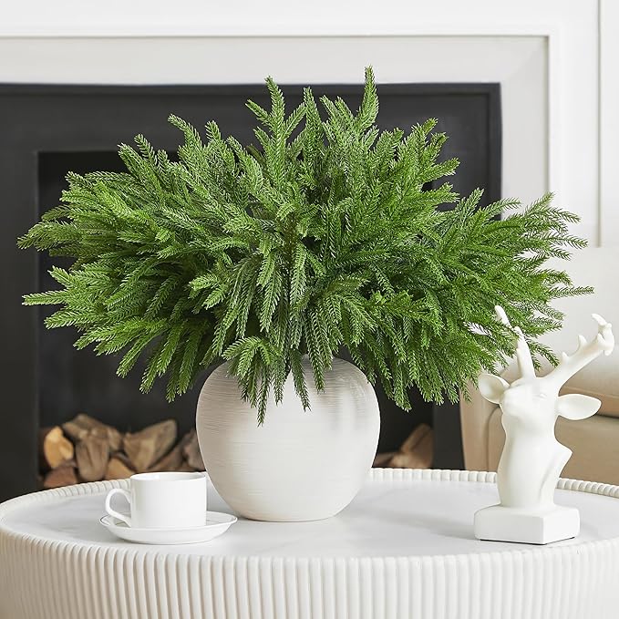 Green faux pine branch stem with layered needle tips, potted in a white vase