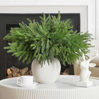 Green faux pine branch stem with layered needle tips, potted in a white vase