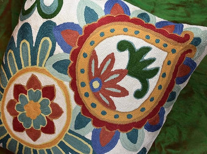 Embroidered floral pillow cover with two circular flower medallions in teal, red, blue, and green