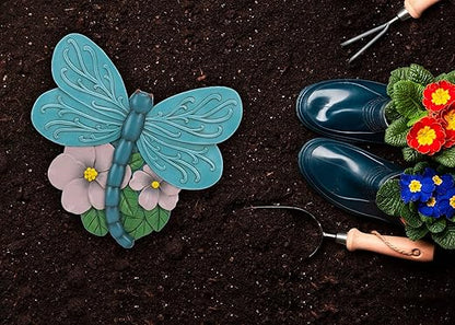 Teal blue dragonfly resin stepping stone on dark soil, raised wings and flower accents