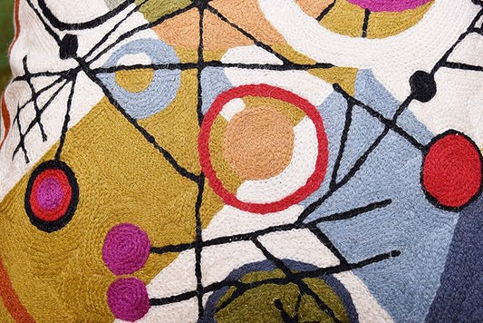 Close-up embroidered wool pillow cover with overlapping circles and black line accents.