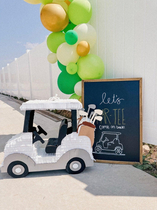 Piñata de carrito de golf con globos verdes y letrero “PAR-TEE” de pizarra