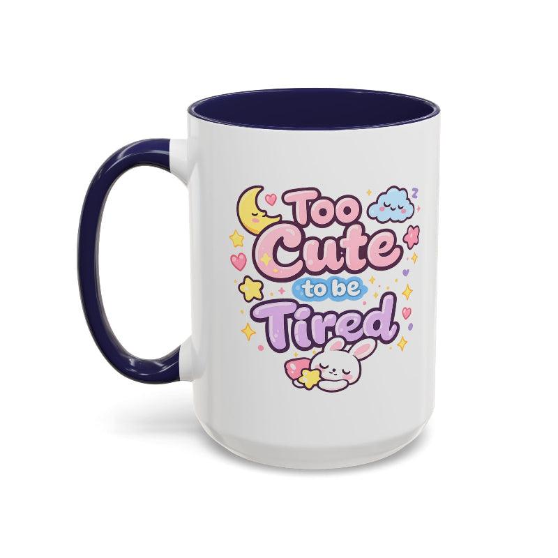 White mug with navy rim and handle, kawaii bunny “Too Cute to be Tired” graphic.