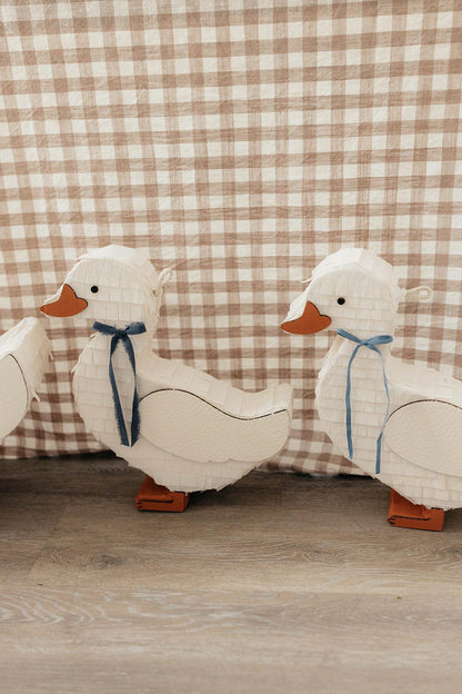 Small duck piñata, white fabric with brown beak and navy ribbon bow