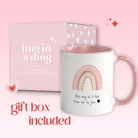 Pink-handled ceramic mug with rainbow hug design, shown with gift box packaging