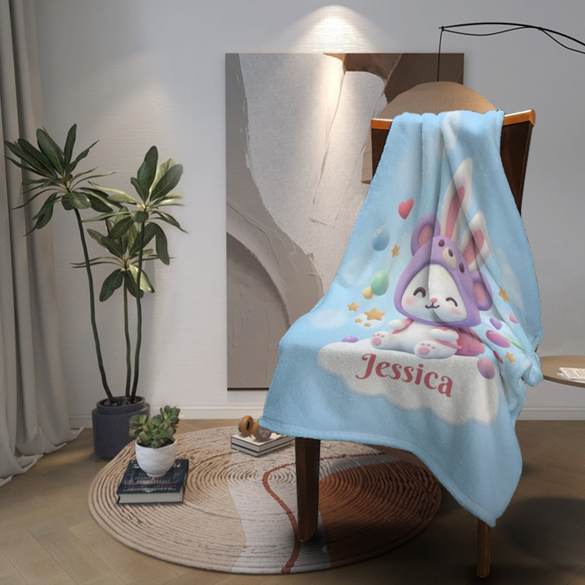 Light blue bunny blanket with hooded rabbit illustration and “Jessica” text at corner
