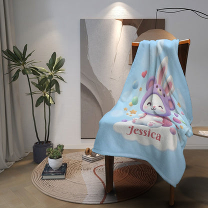 Light blue bunny blanket with hooded rabbit illustration and “Jessica” text at corner