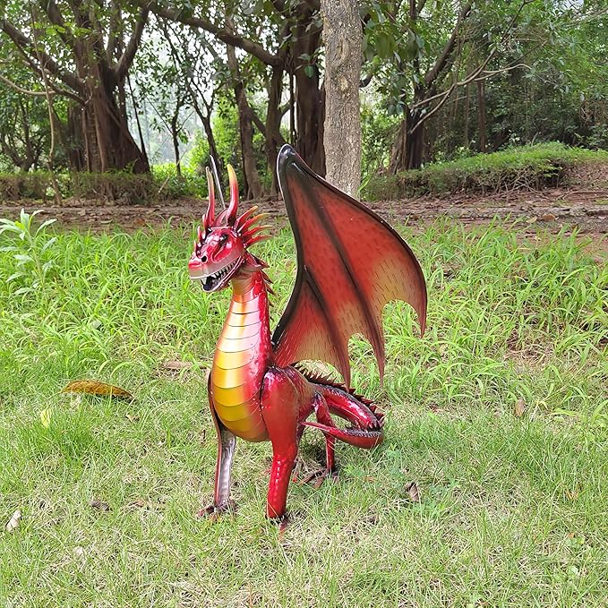 Red and gold dragon figurine standing on grass, three-quarter view with curled tail