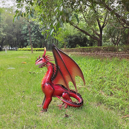 Red dragon statue on grass, side view with wings raised and long whiskers