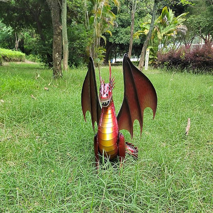 Red dragon statue seen from behind on grass, large wings and gold striped body