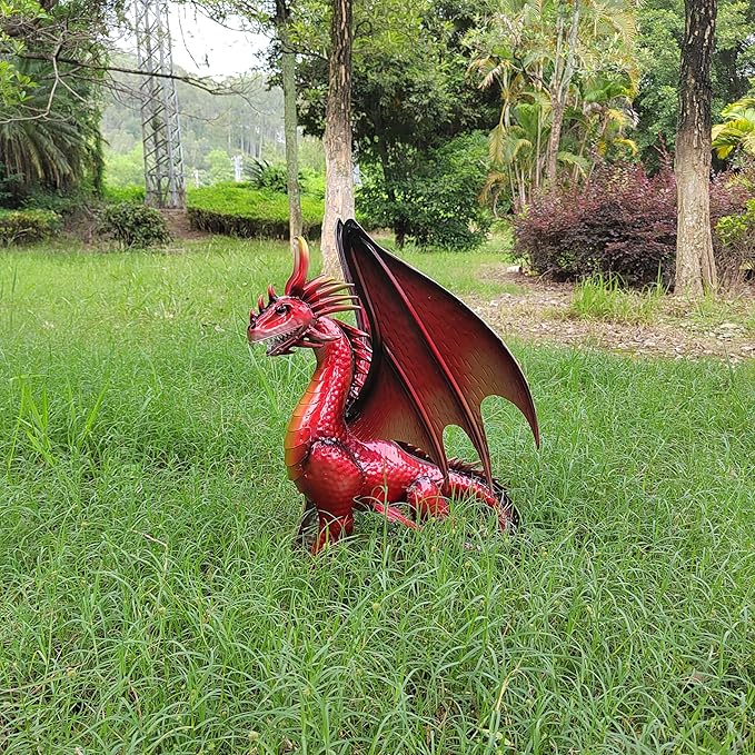 Red dragon figurine crouched on grass with wings open and spiked back