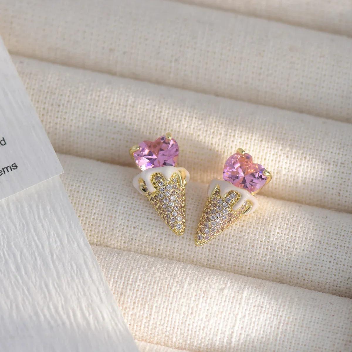 Pink heart stud earrings with gold-tone triangular glitter dangle, close-up pair