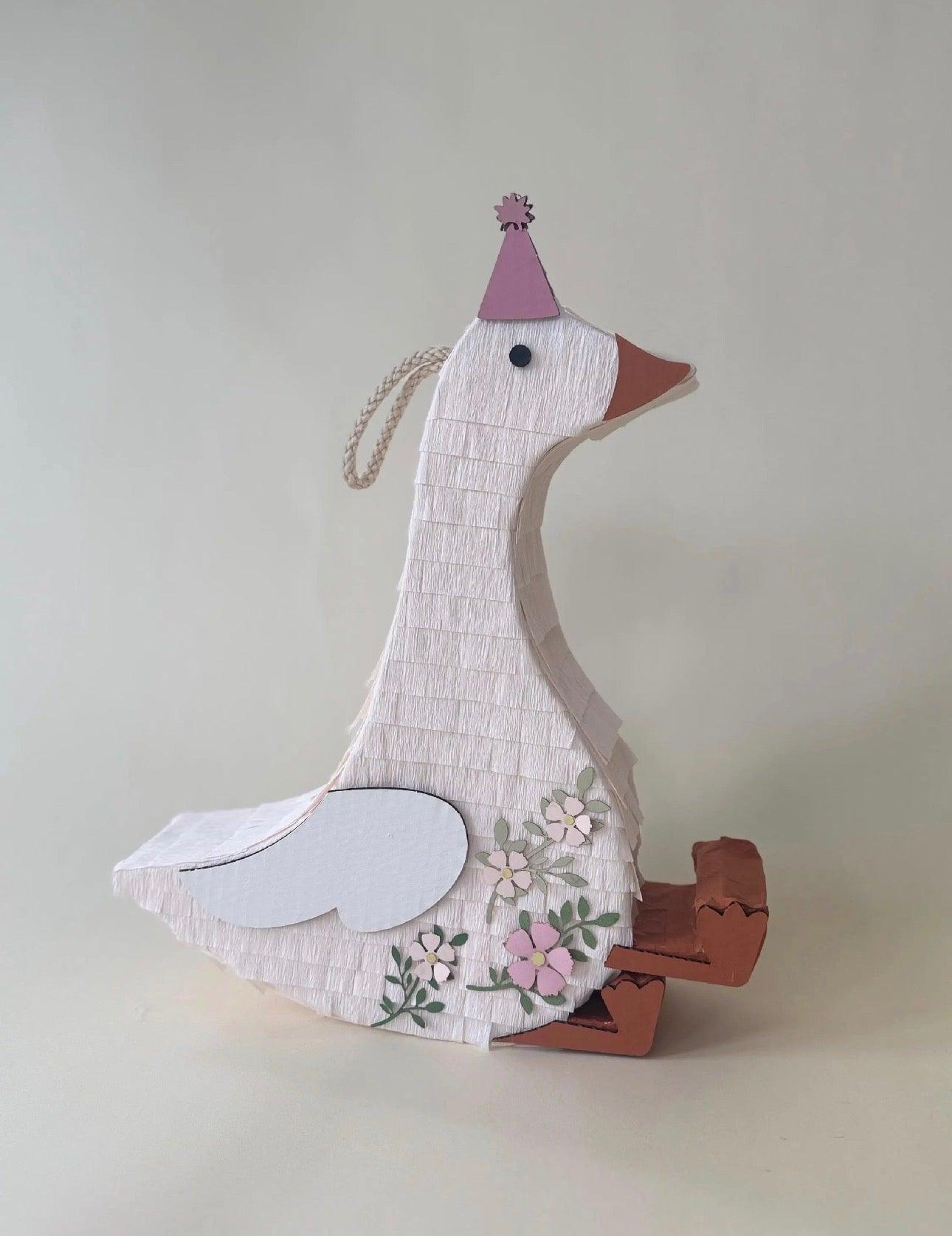 Pink cap sitting goose piñata with floral fabric and hanging string