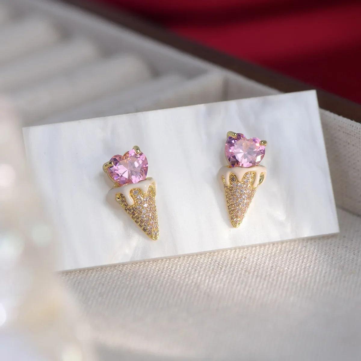 Pink heart and gold-tone triangular glitter earrings with small stud backs, pair