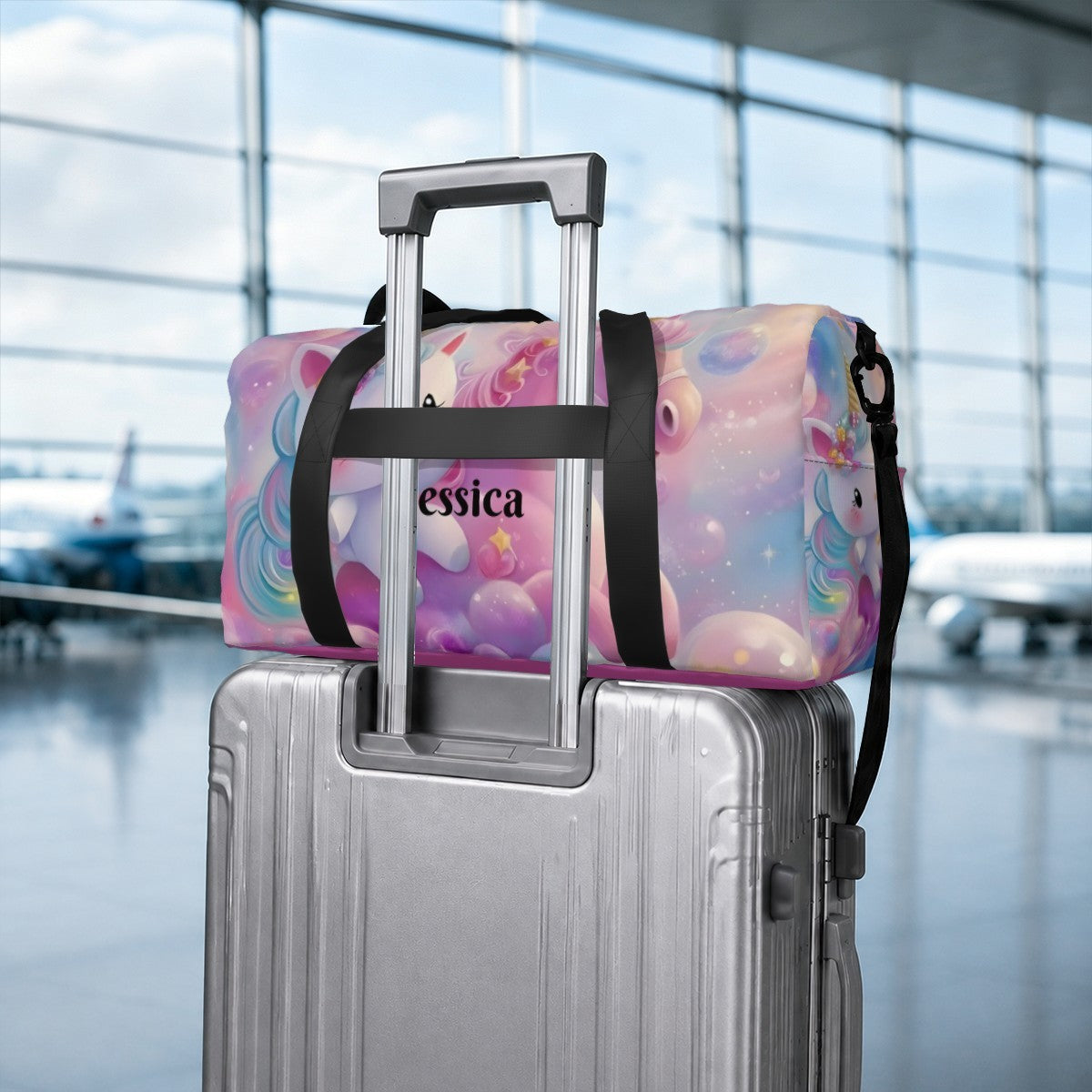 Pastel unicorn duffel bag with black straps secured to rolling luggage handle