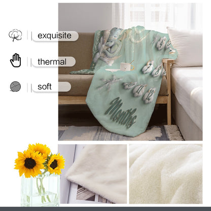 Mint milestone blanket on couch with dragon graphic and numbered months design