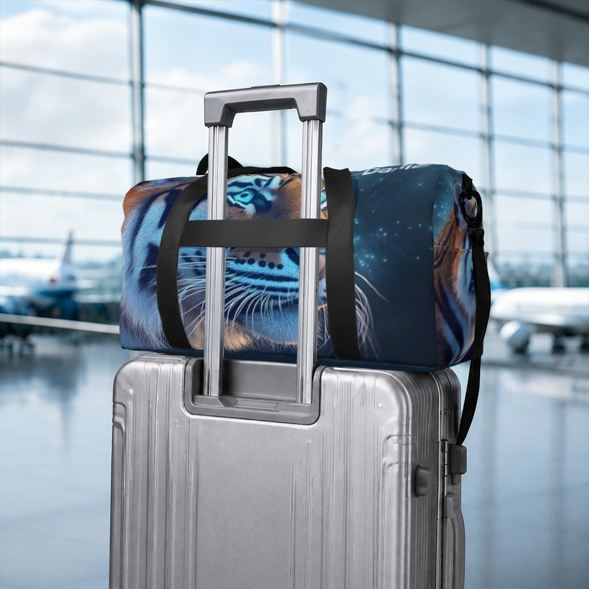 Blue duffel bag with tiger print, strapped onto a rolling suitcase handle with black band.