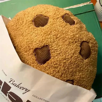 Tan cookie plush pillow with brown stitched chocolate-chip shapes