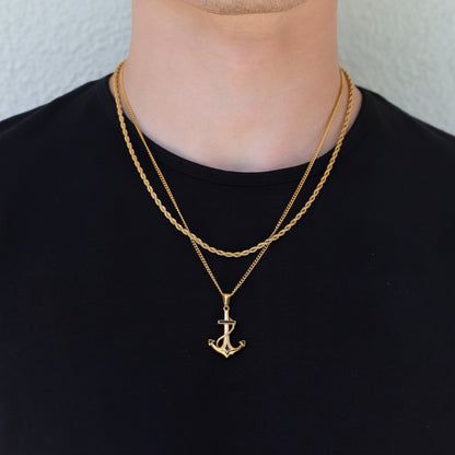 Gold anchor pendant necklace with double-layer chain look on neck and chest