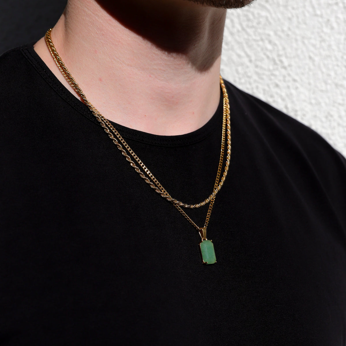 Gold-tone layered chain necklace with square green stone pendant