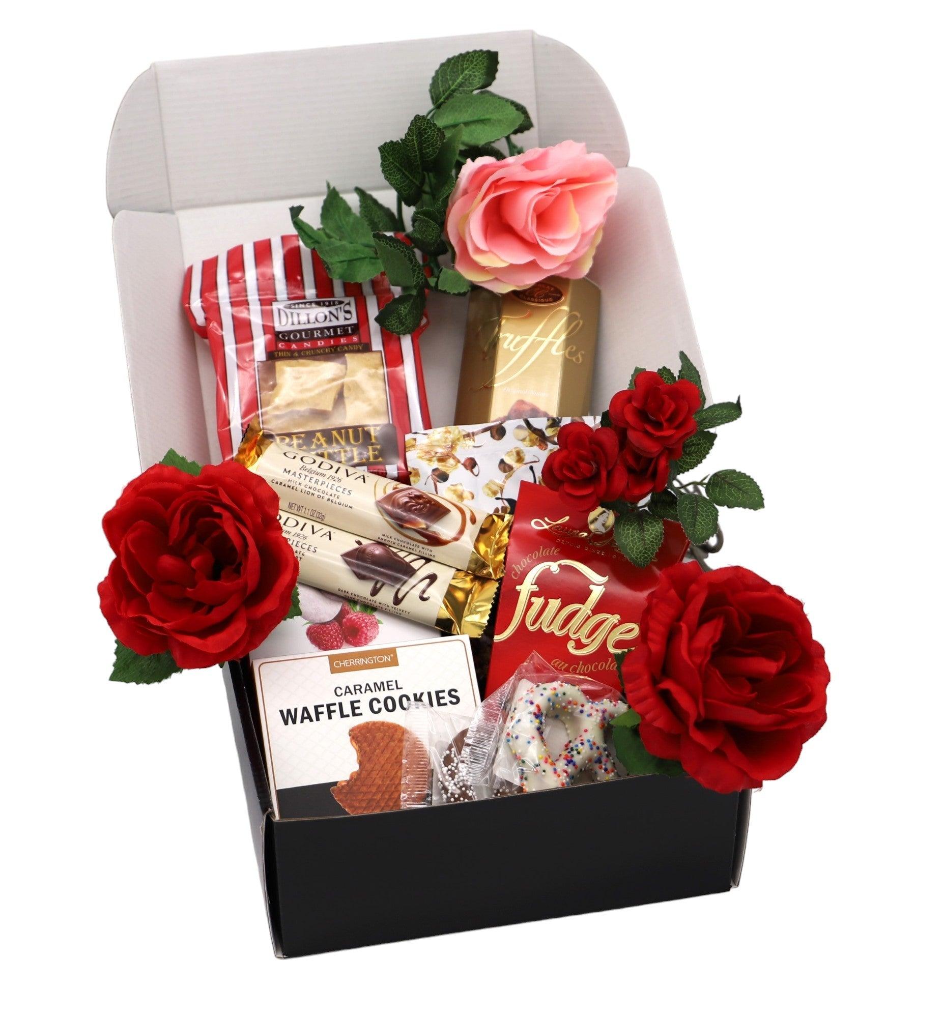 Valentine gift box with black base, packaged treats, and red roses with a pink rose