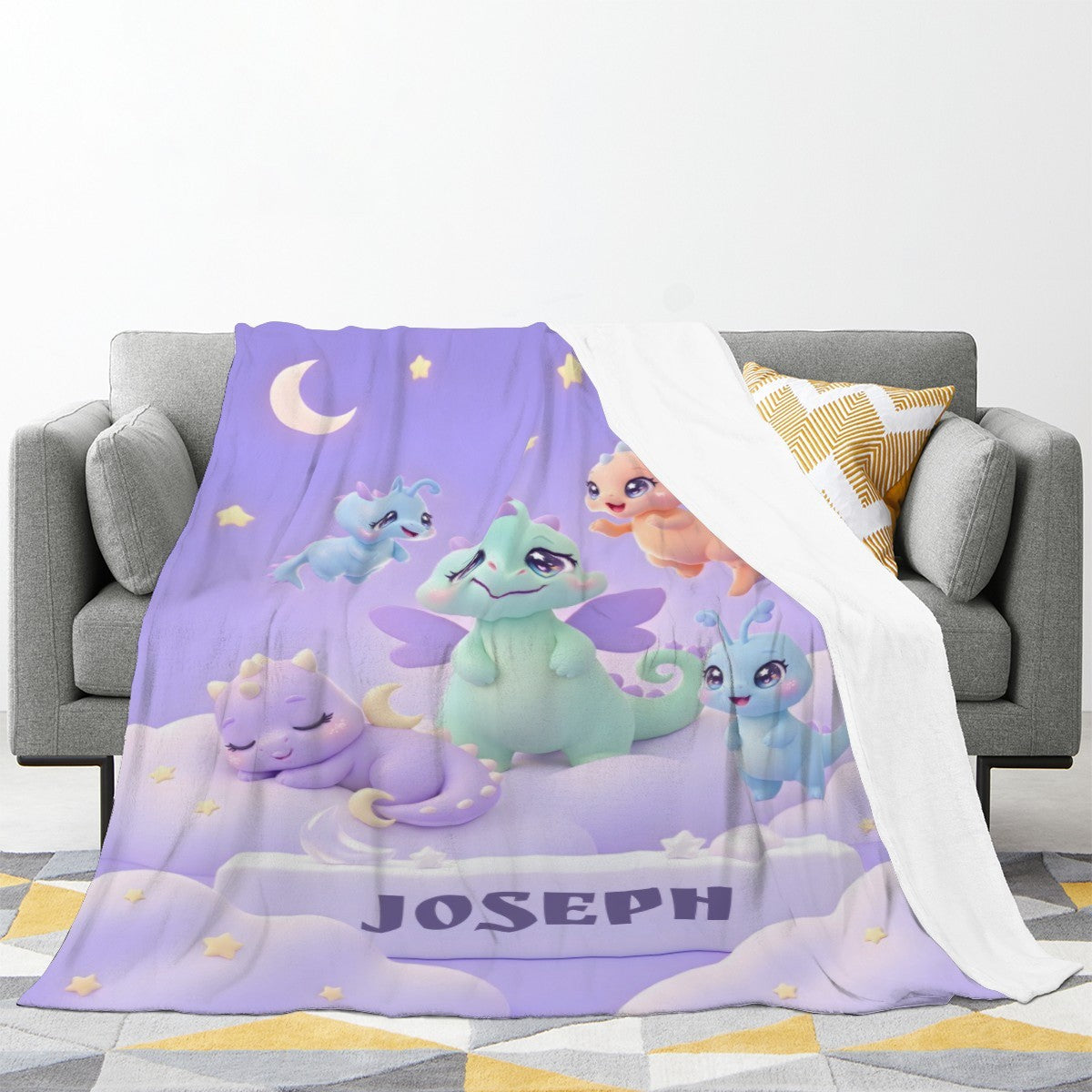 Purple dragon-themed blanket with stars and moon, 'JOSEPH' text, draped on couch