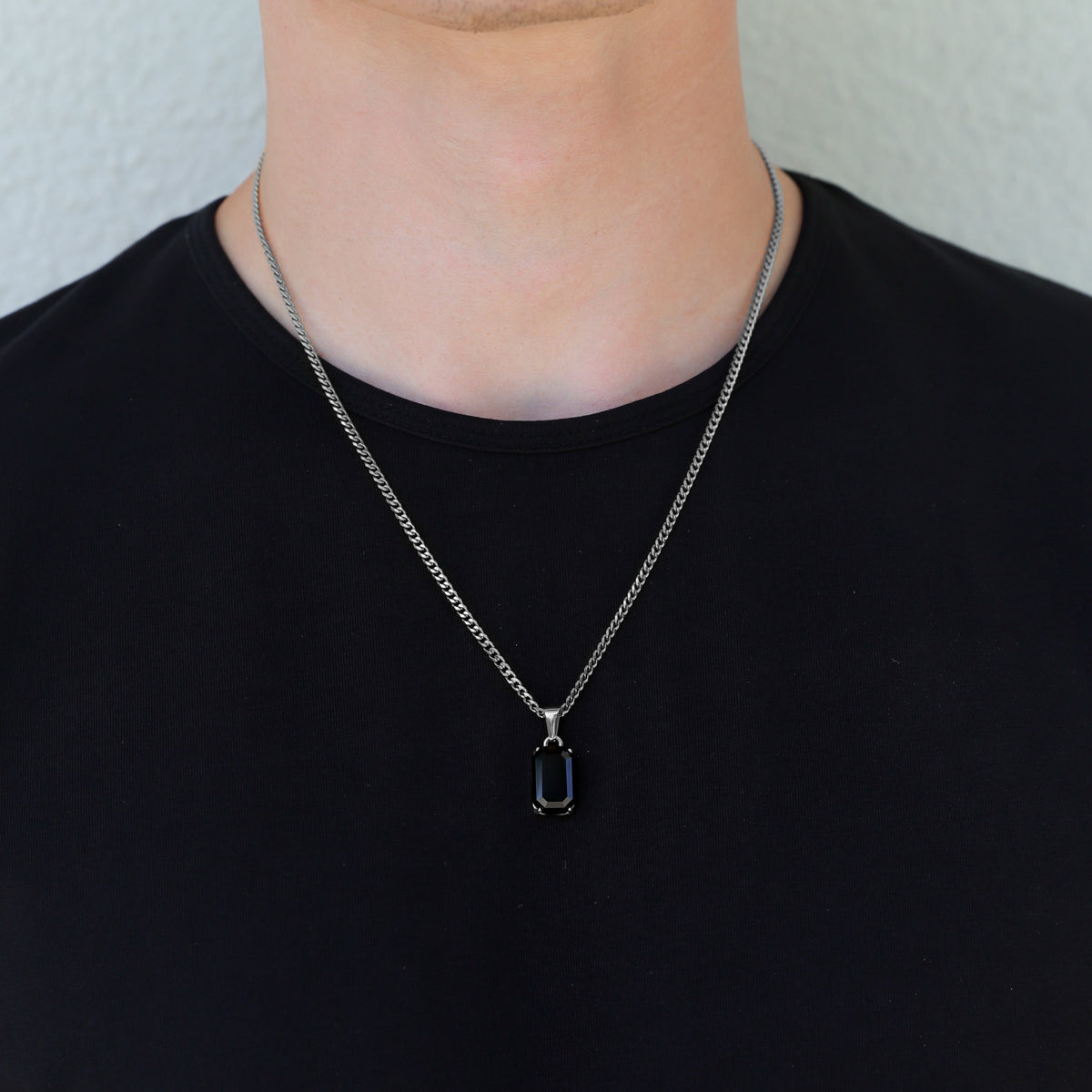 Silver-tone onyx stone pendant necklace set with rectangular pendant on chest