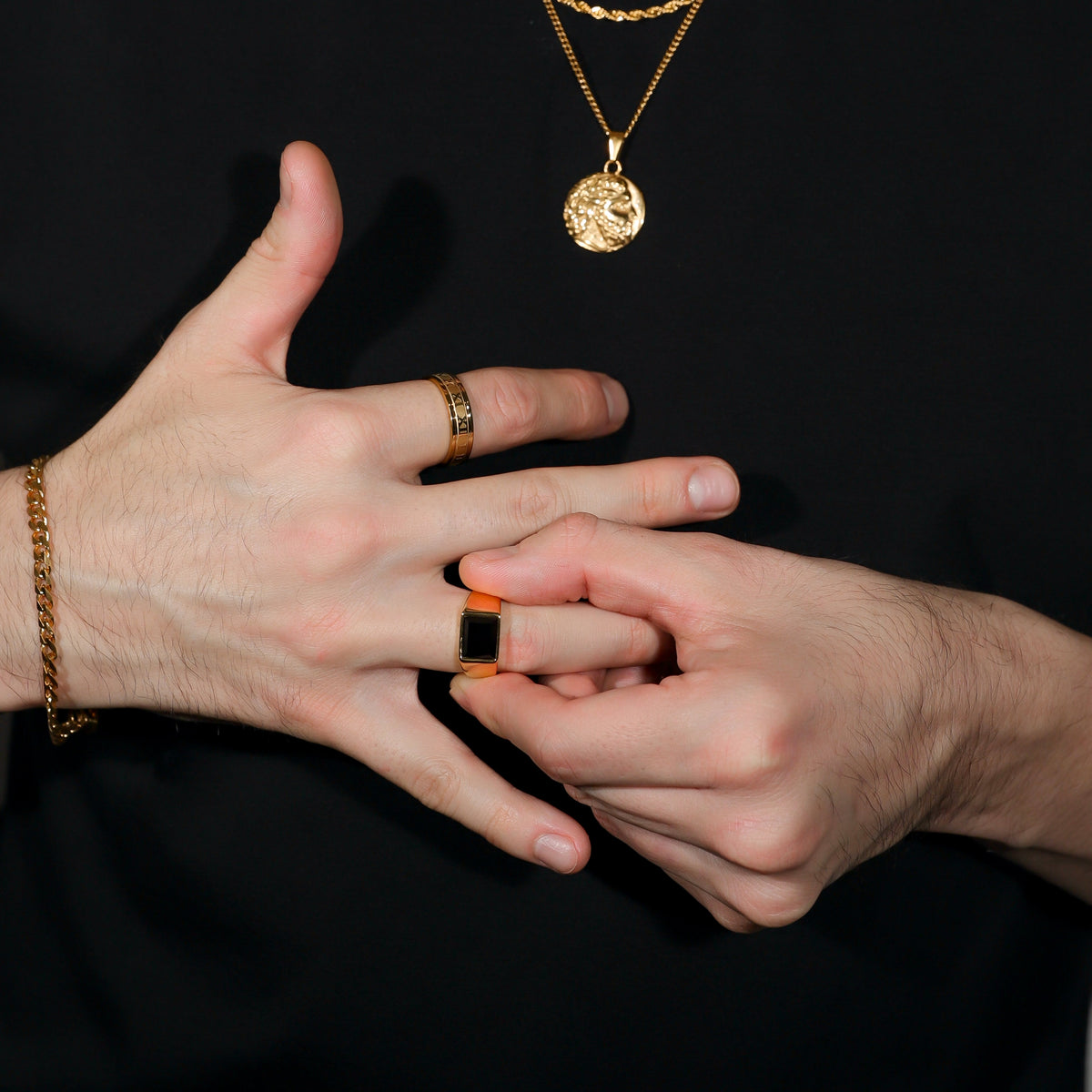 Square black signet ring on fingers, gold PVD steel band