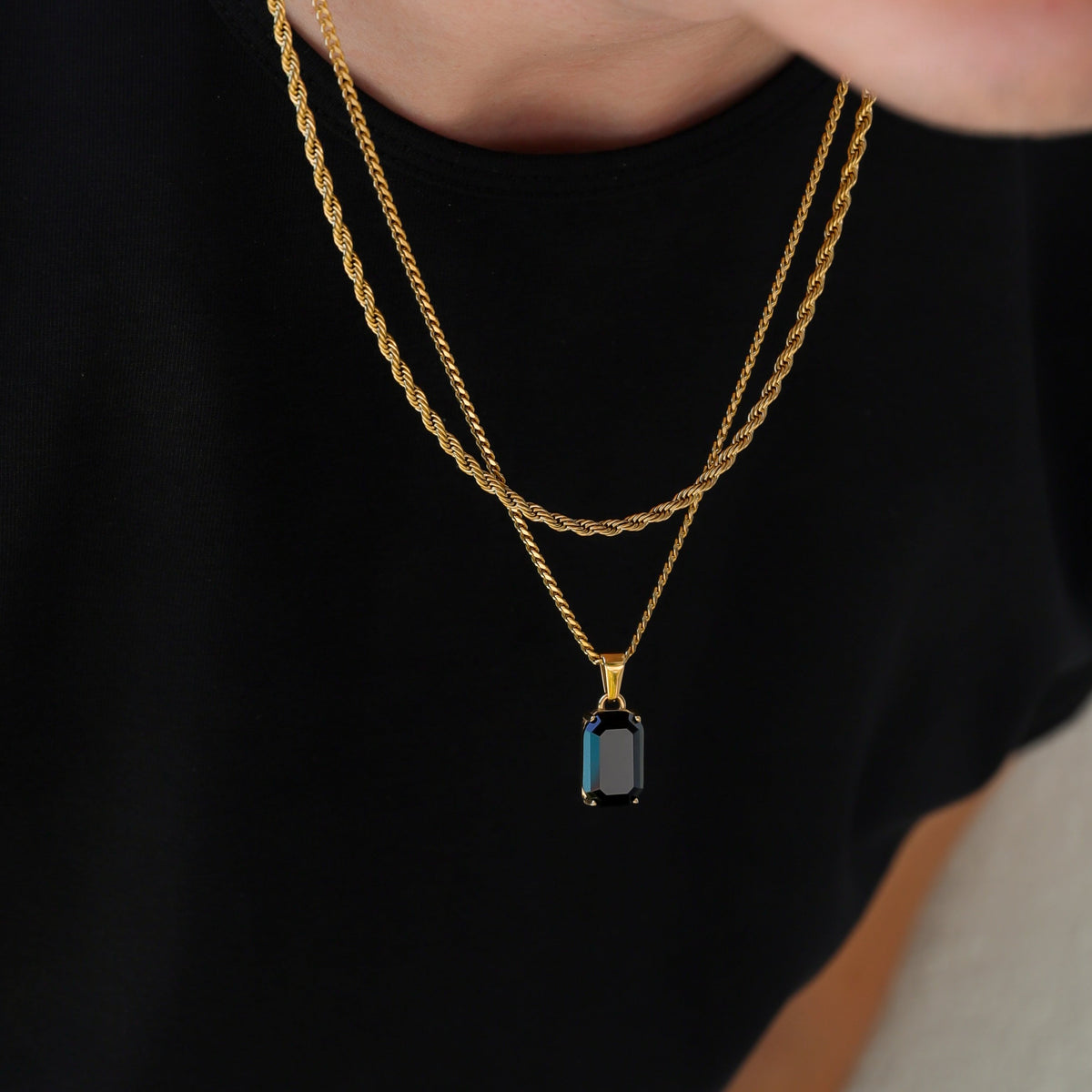 Gold-tone onyx pendant necklace with stacked chain links and rectangular charm