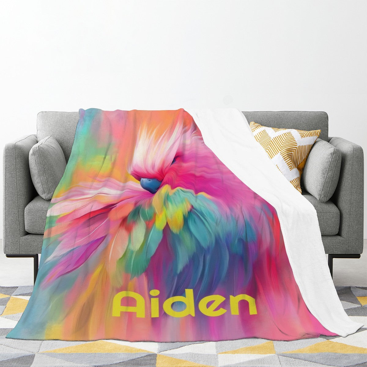 Personalized parrot name blanket spread on couch with rainbow bird artwork