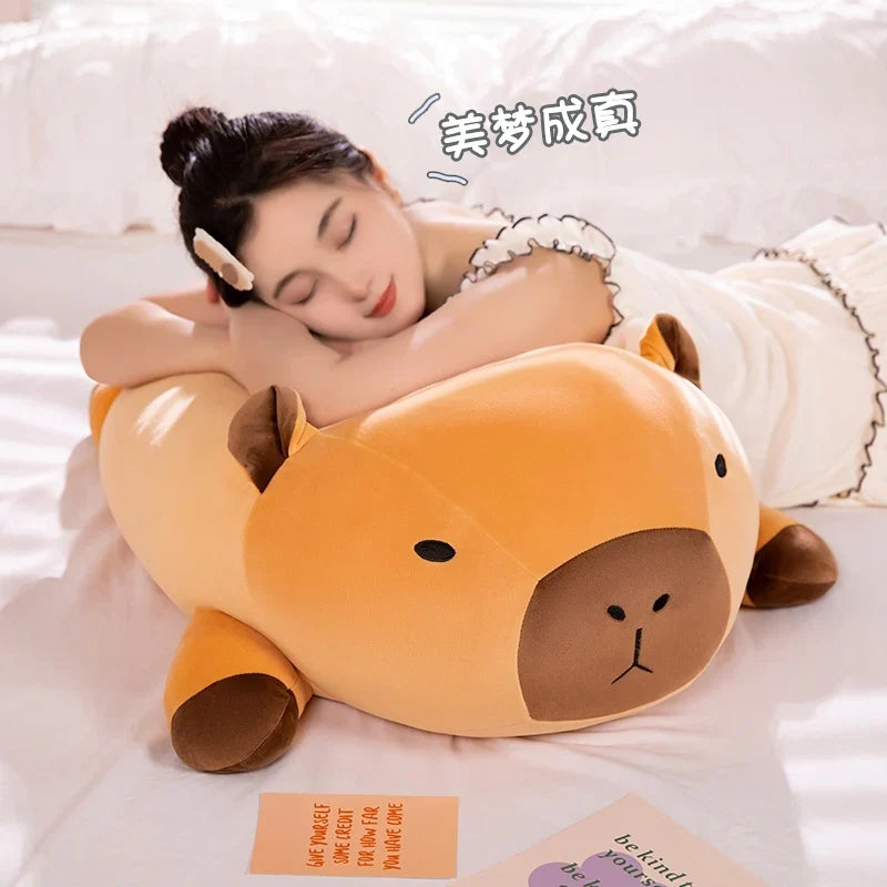 Orange capybara plush pillow with brown snout and stitched eyes on bed