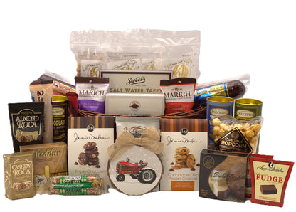 Assorted Christmas gift basket with wrapped chocolates, cookies, and a decorative bow.