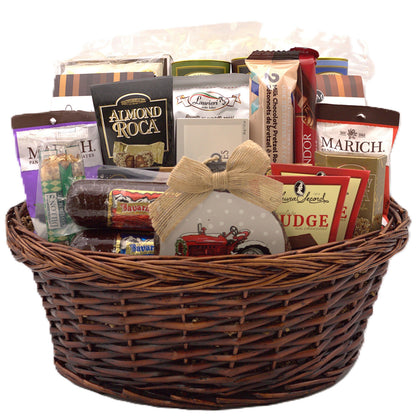 Woven wicker gift basket filled with assorted chocolates and cookies, wrapped in plastic.