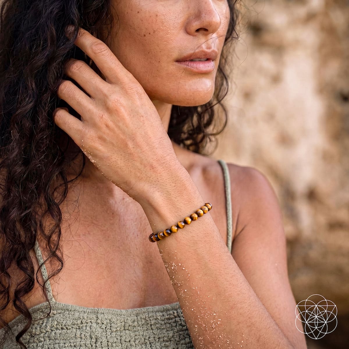 Tiger’s eye bead bracelet on bare wrist with small metallic bead highlights