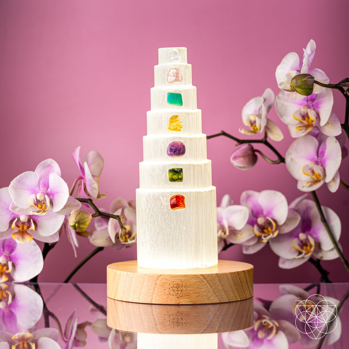 Glowing stacked crystal tower lamp with multicolor stone inlays and round wood base