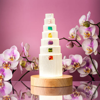 Glowing stacked crystal tower lamp with multicolor stone inlays and round wood base