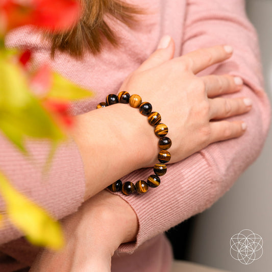 Tiger’s eye beaded bracelet on a hand, featuring dark and golden striped beads