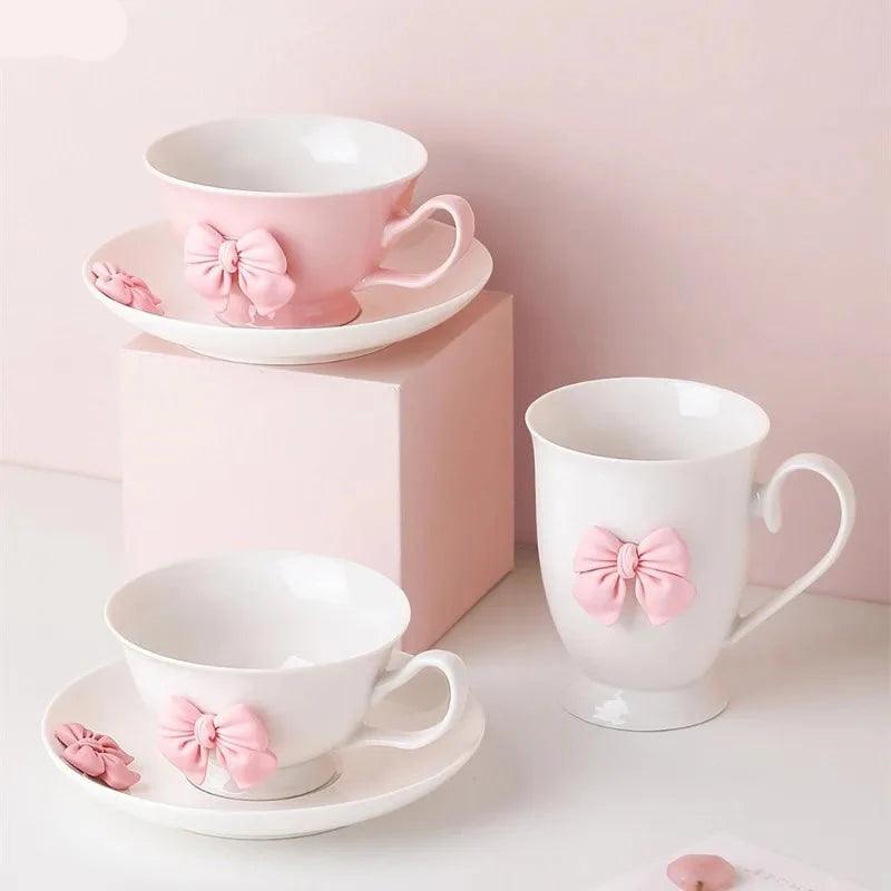 Porcelain tea cup and saucer set in white with pink bow detail, handle on right