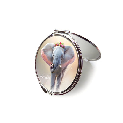 Open silver compact mirror with a floral elephant design on the lid.