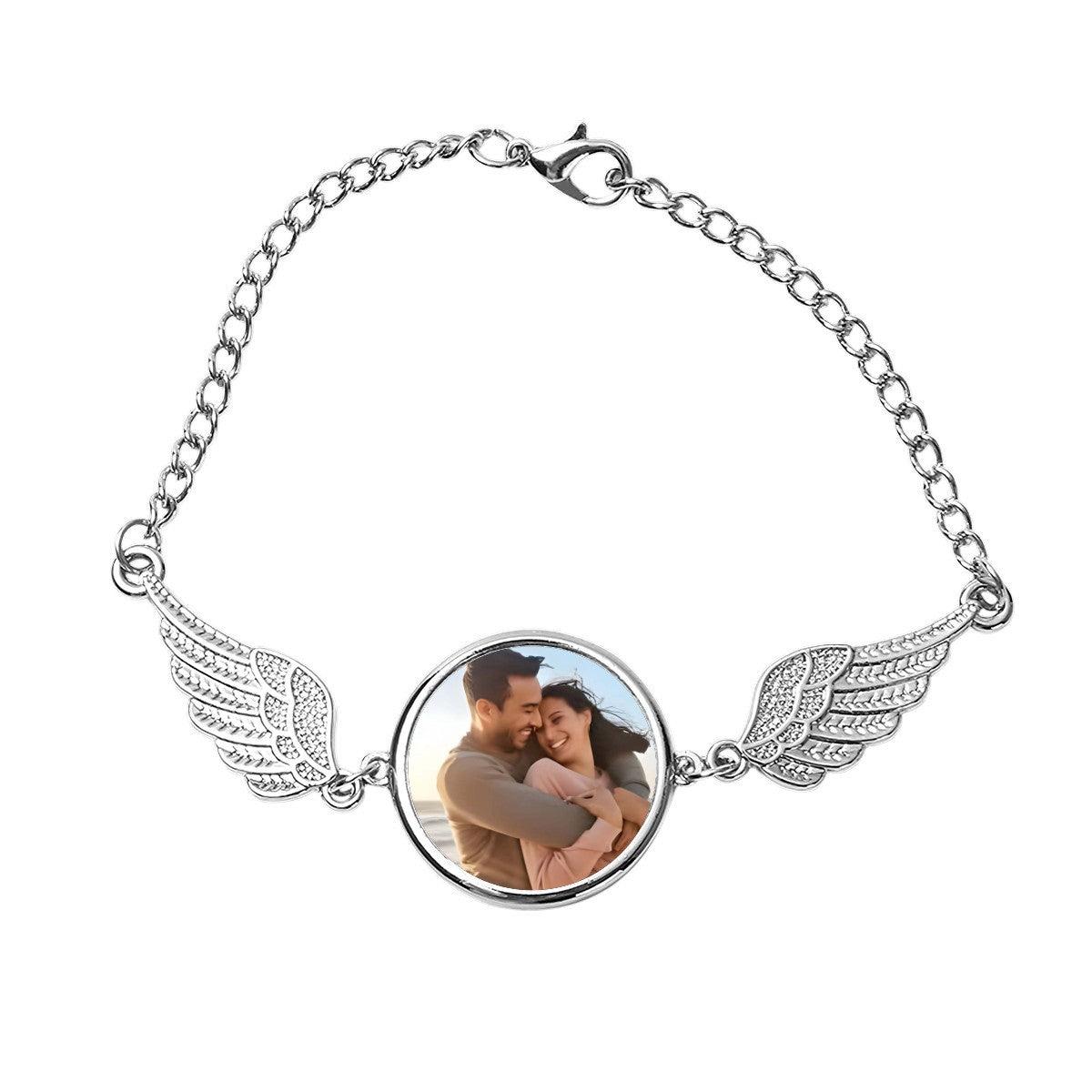 Silver angel wings photo bracelet with round locket showing a couple selfie